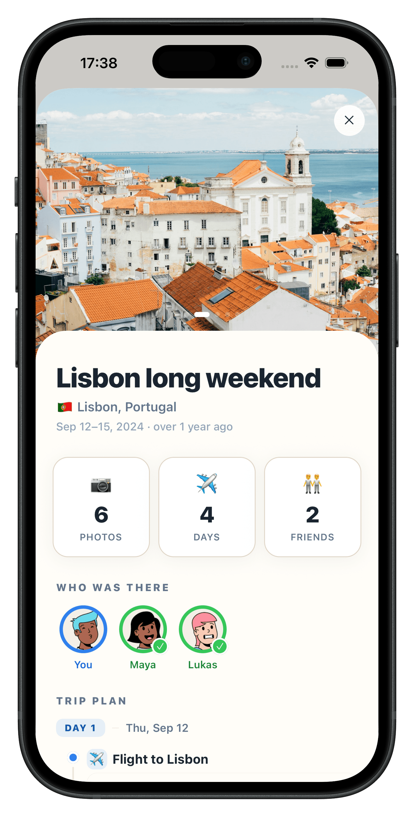Atlasnap trip detail page for a Lisbon long weekend showing a hero photo over the rooftops, 6 photos, 4 days, 2 friends and the start of the Day 1 plan with a flight to Lisbon.